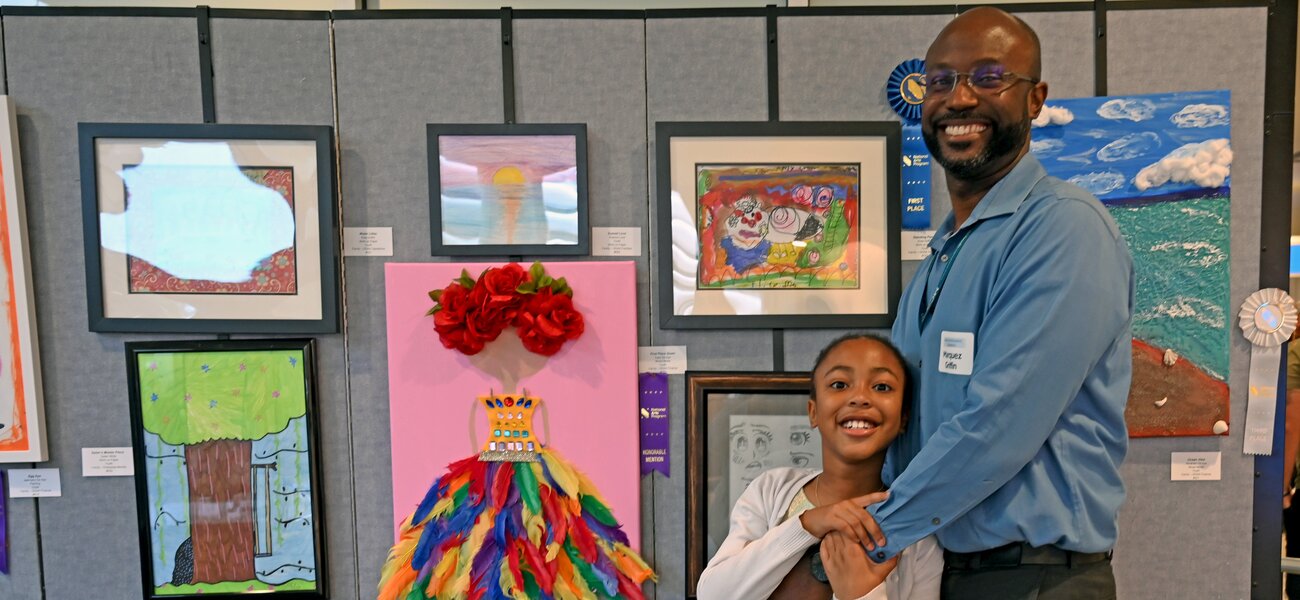 Pictured here above is First Place Youth winner, Elise Griffin who poses with dad Marquez from GOAA Operations.