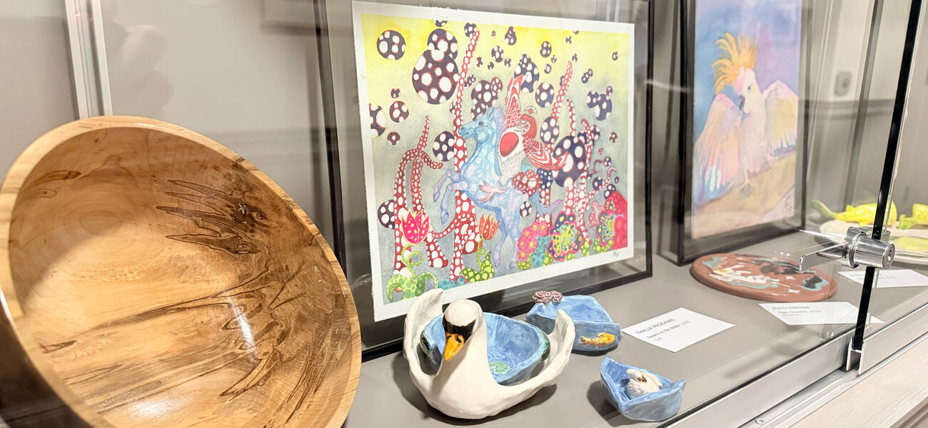 Display case filled with artworks from the 17th Annual National Arts Program Exhibit displayed in Manchester City Hall.