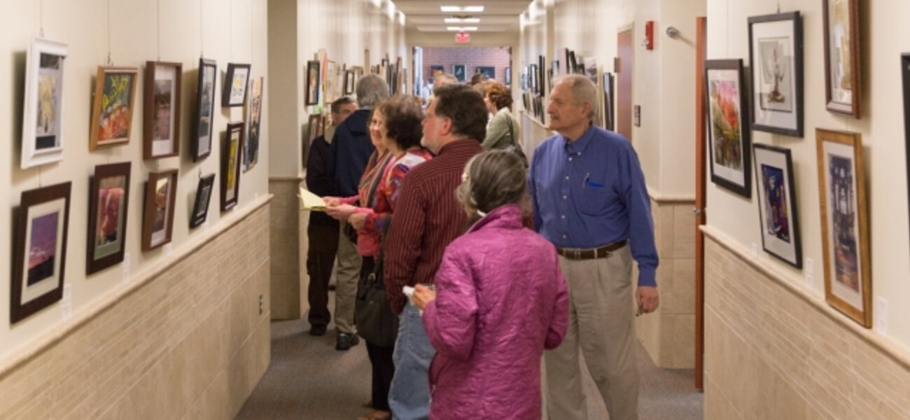 9th Annual Exhibit Attendees browsing the artwork filled hallways of the Regional Emergency Training Center at Camden County College