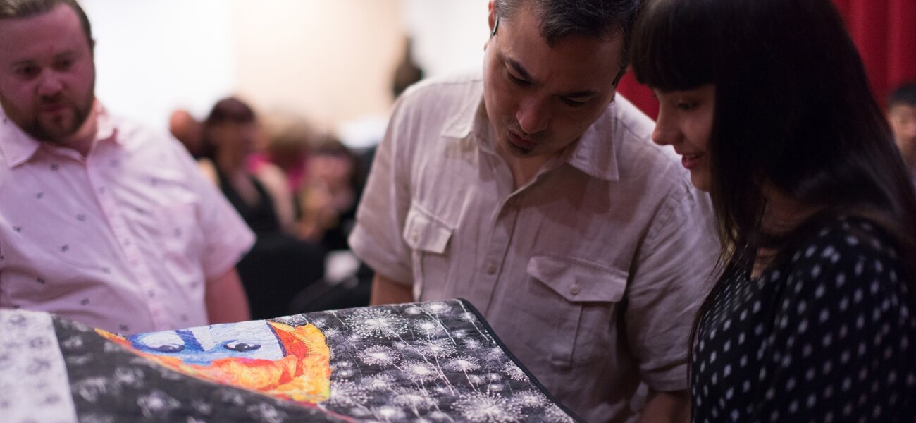 11th Annual Exhibit Attendees taking a closer look at the details of Jodi Davila's award winning textile piece.
