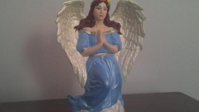 Angel kneeling in the clouds