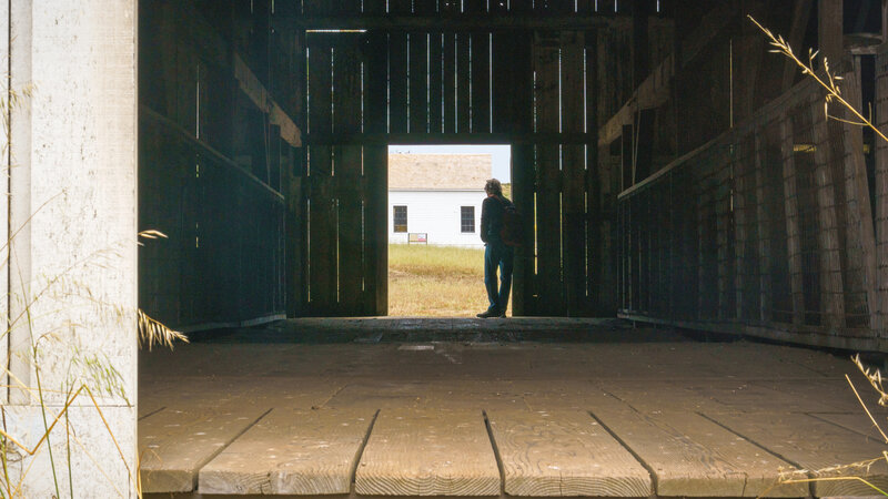 Man in barn door