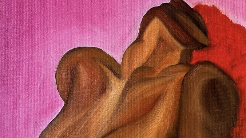 The cropped figure of a woman sitting up with her head thrown back against a pink background. Her hair is bright red, flowing behind her.