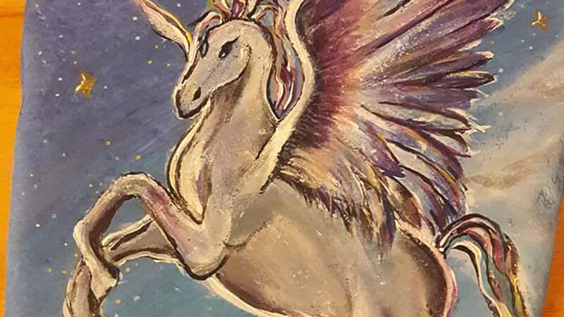 Fantasy Pegasus flying among the clouds and stars.