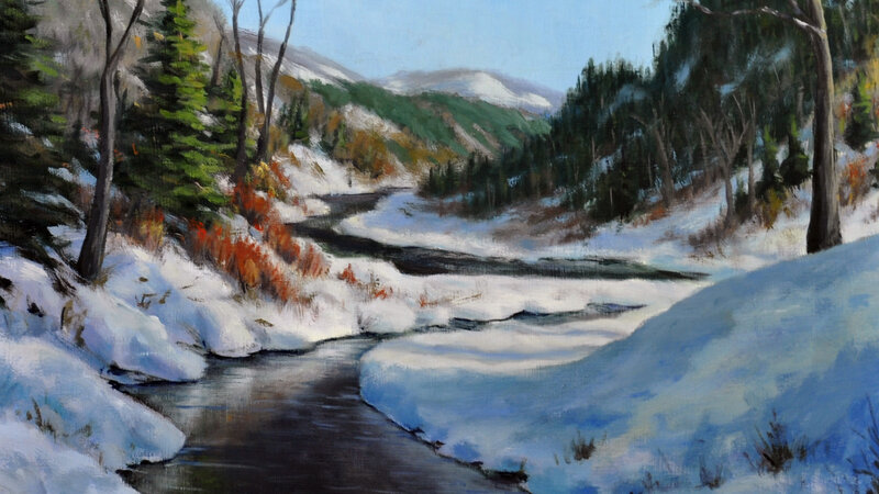 Mountain winter scene with an open water river running though it.