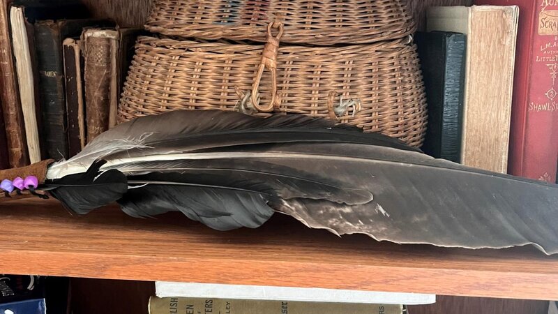 an old basket sits on a shelf with books
