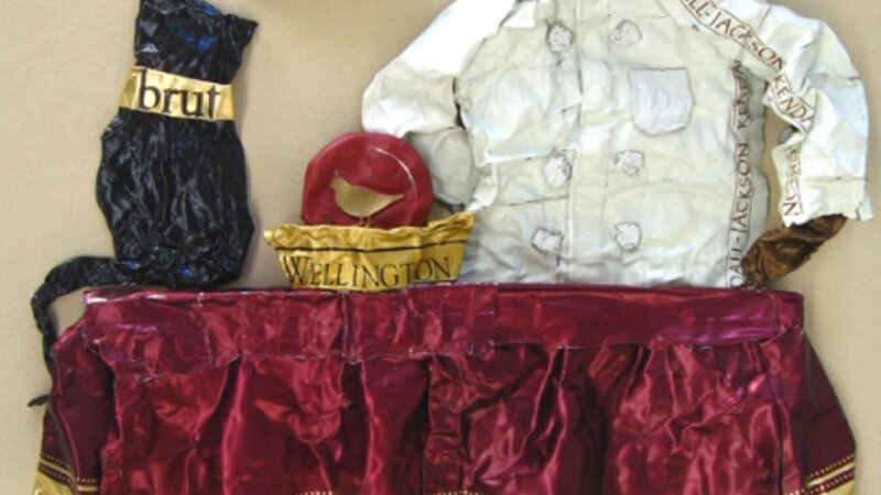 Sculpture on paper of a chef and his finicky cat, made entirely from wine capsules