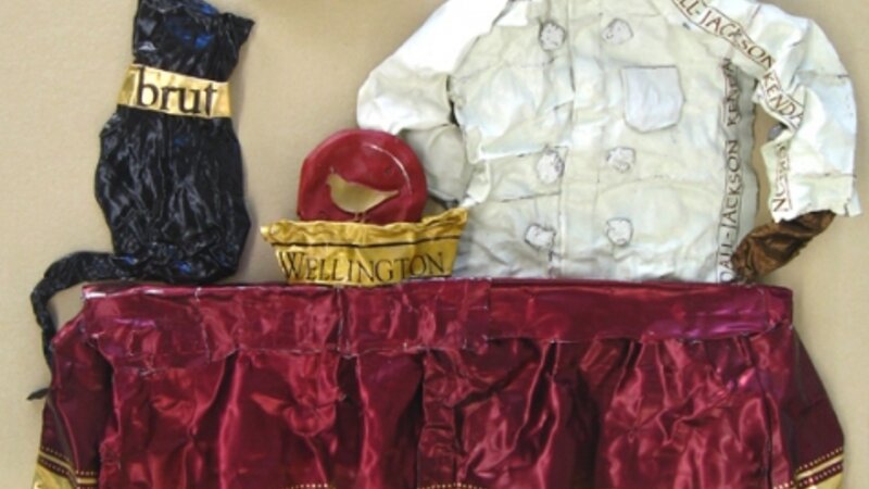 Sculpture on paper of a chef and his finicky cat, made entirely from wine capsules