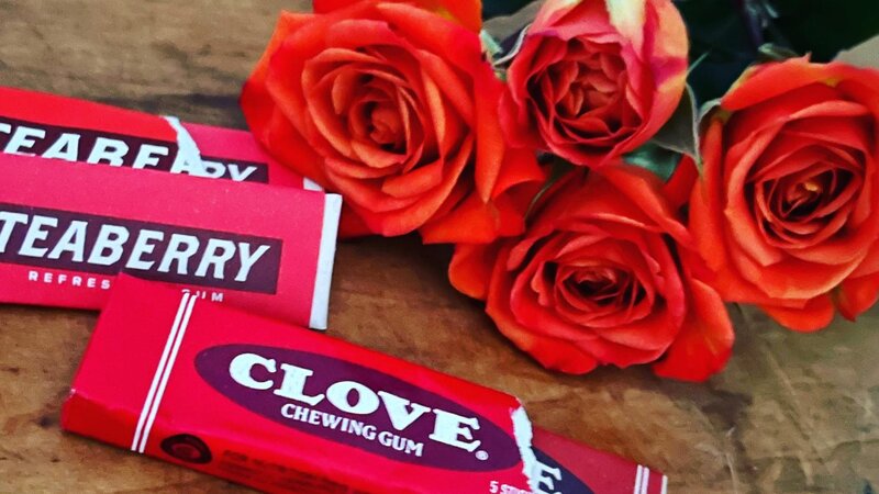 orange roses next to a pack of gum