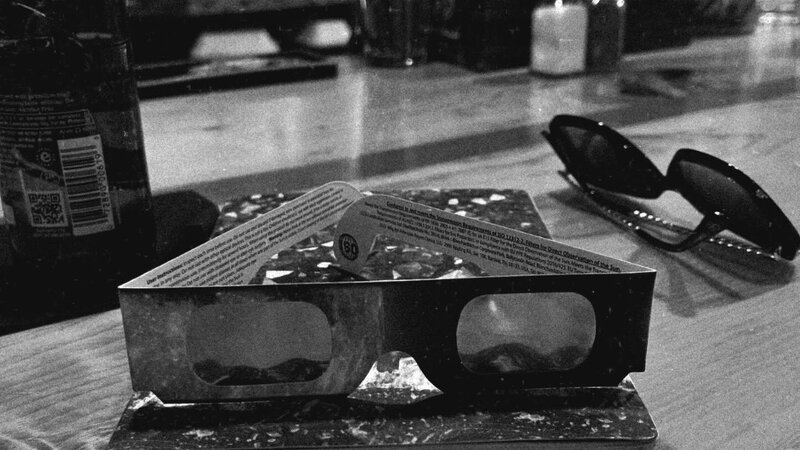 black and white image of solar eclipse glasses sits on a counter