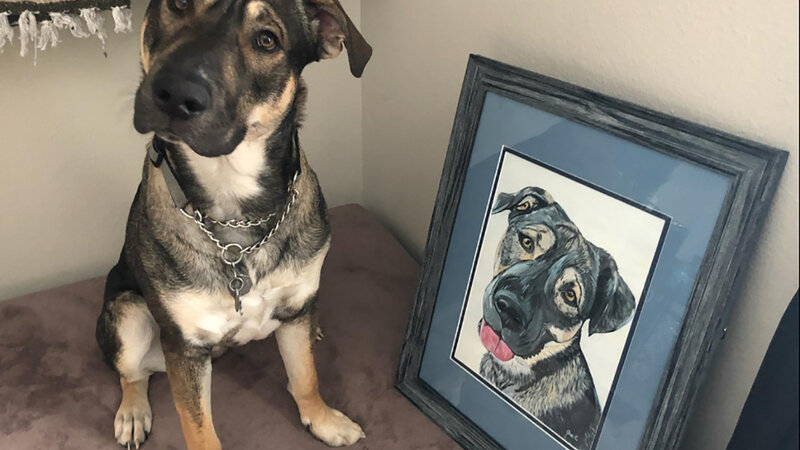 Dog poses with his painted portrait on canvas.