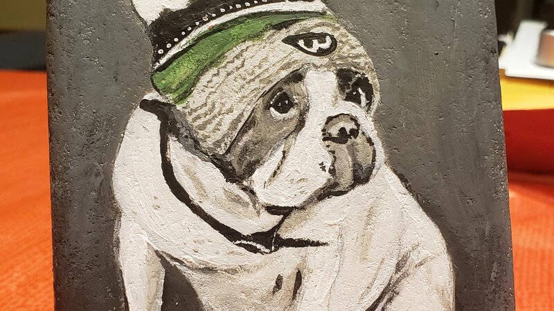 Painting of Donnie Wahlberg's white and grey bulldog that passed, wearing a winter hat.
