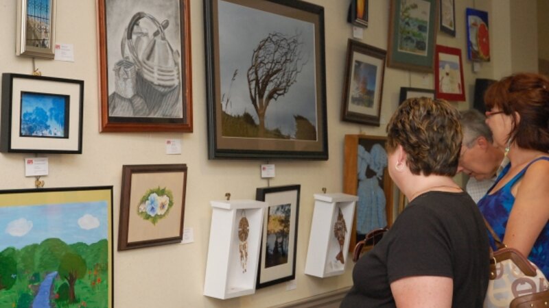 6th Annual Exhibit Attendees admiring one of the walls filled with artwork