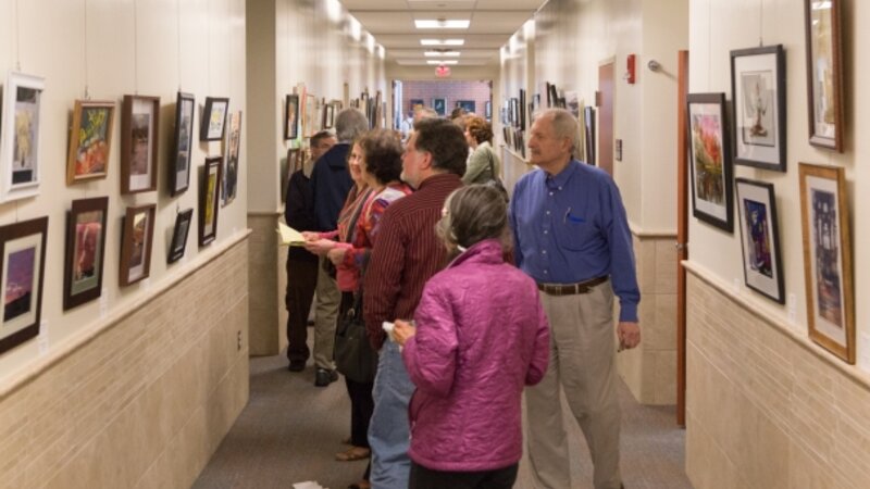 9th Annual Exhibit Attendees browsing the artwork filled hallways of the Regional Emergency Training Center at Camden County College