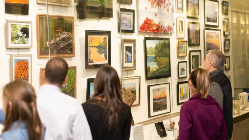 9th Annual Exhibit Attendees taking in one of  beautiful cases of artwork on display at the MSP International Airport