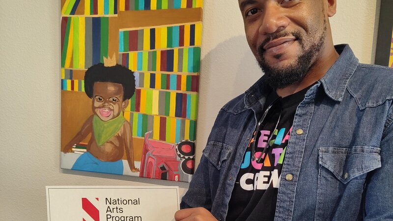 small boy in a crown sitting in front of a colorful backdrop