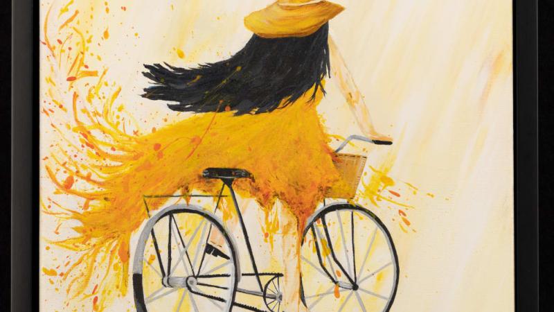 a girl riding a bike with a flowing yellow dress