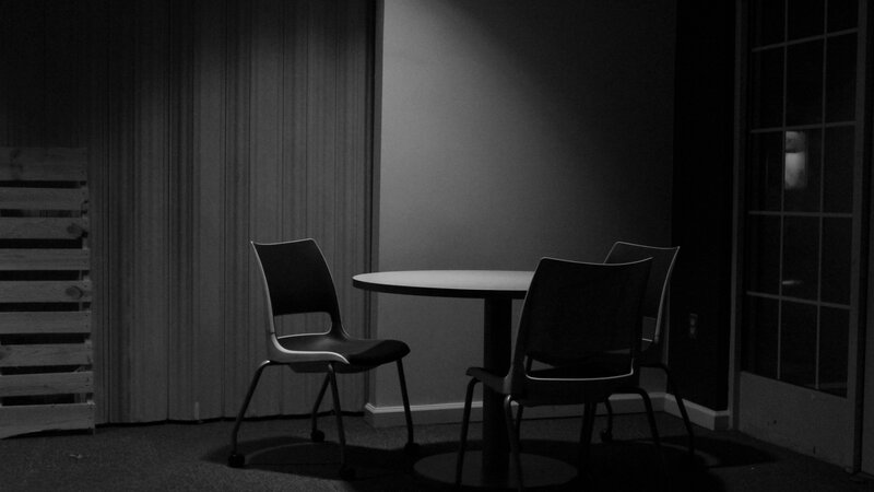 black and white photograph of an empty table and chairs