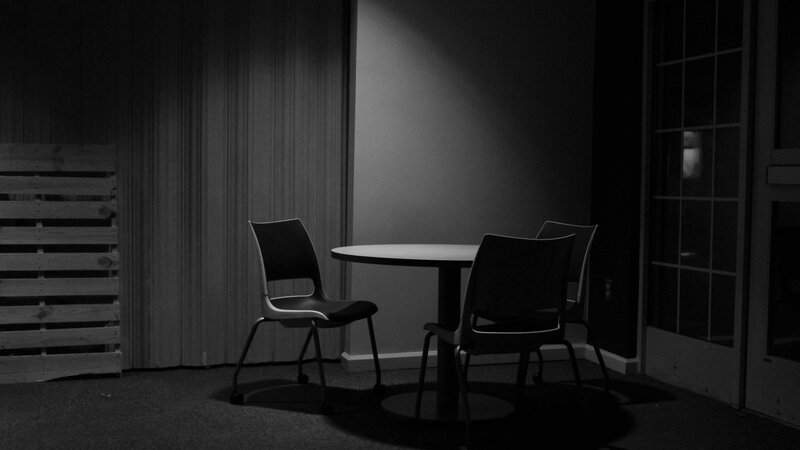 black and white photograph of an empty table and chairs