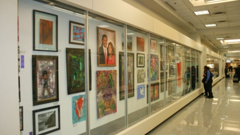1st Exhibit Employees and travelers pausing to take in the artwork on display in the Gallery T Display Cases