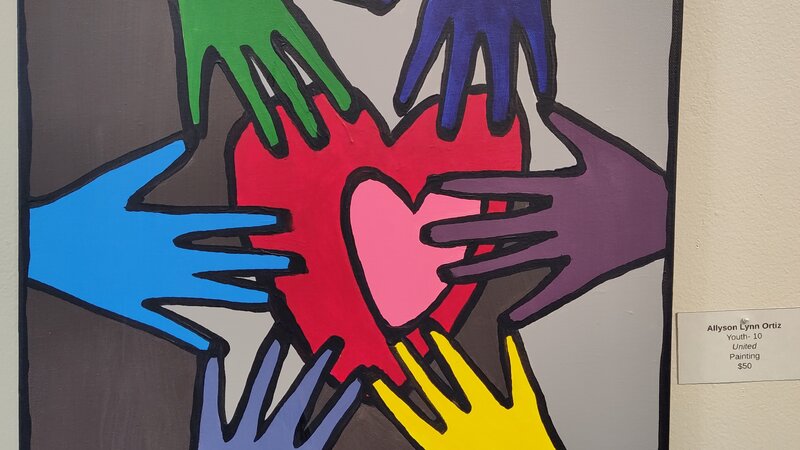 Painting of Multicolored hands touching a heart at the center of the canvas