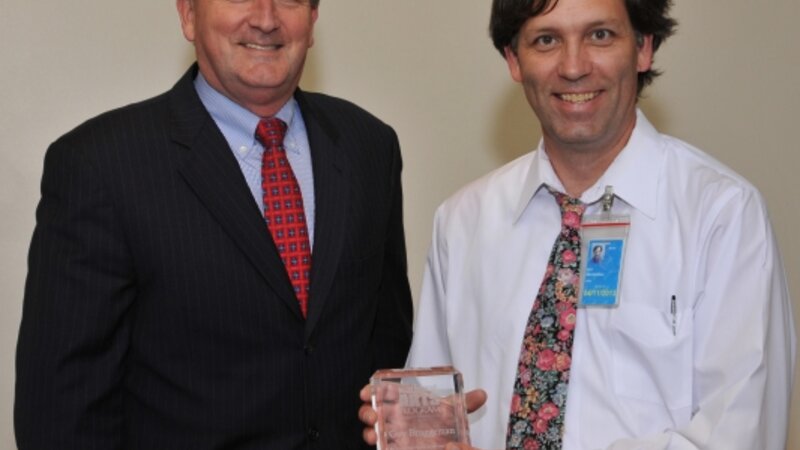 5th Annual Exhibit Coordinator Guy Bruggeman with Jeff Fegan, CEO, was presented the NAP's 5th Anniversary Award