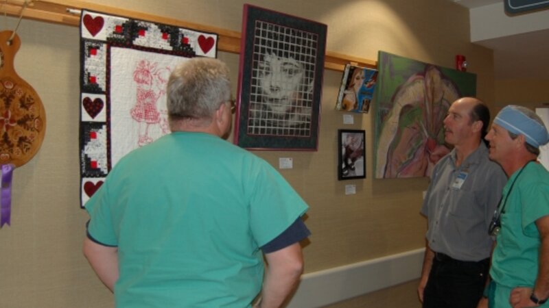 2nd Annual Exhibit Employees of the hospital stop to discuss the artwork on display