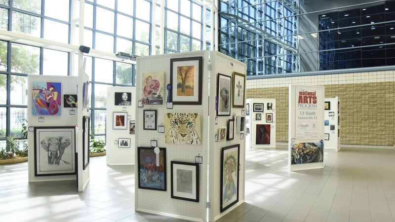 5th Annual Exhibit The Atrium of UF Health Jacksonville filled with vibrant art from this year's show.