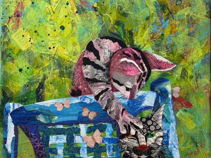 Torn paper collage of two playful cats on a blue chair