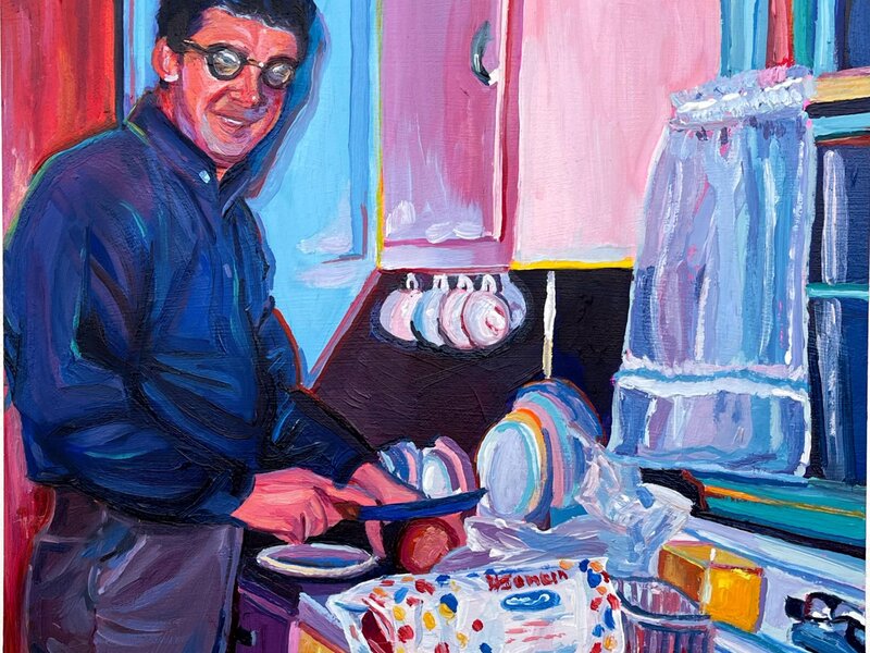 A mid century man preparing a sandwich with wonder bread in his pink and blue kitchen. He's smiling at the camera. 