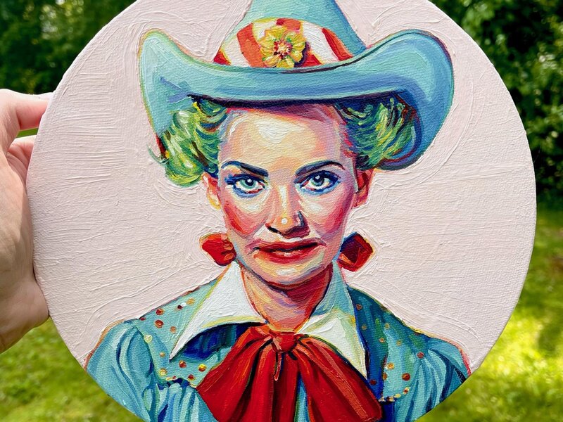 A mid century looking female rodeo clown on a round canvas. Her makeup is smudged. She's not terrifying, but a little off putting. Her hair is green and she has a teal cowboy hat with a yellow flower on the brim. 