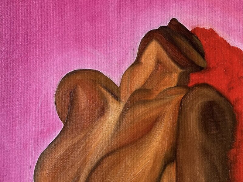 The cropped figure of a woman sitting up with her head thrown back against a pink background. Her hair is bright red, flowing behind her.