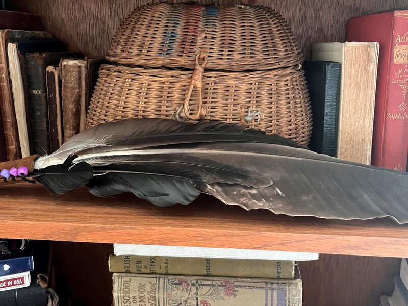 an old basket sits on a shelf with books