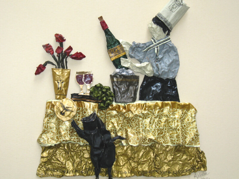 sculpture on paper of a chef and his unruly cat, made entirely from wine capsules
