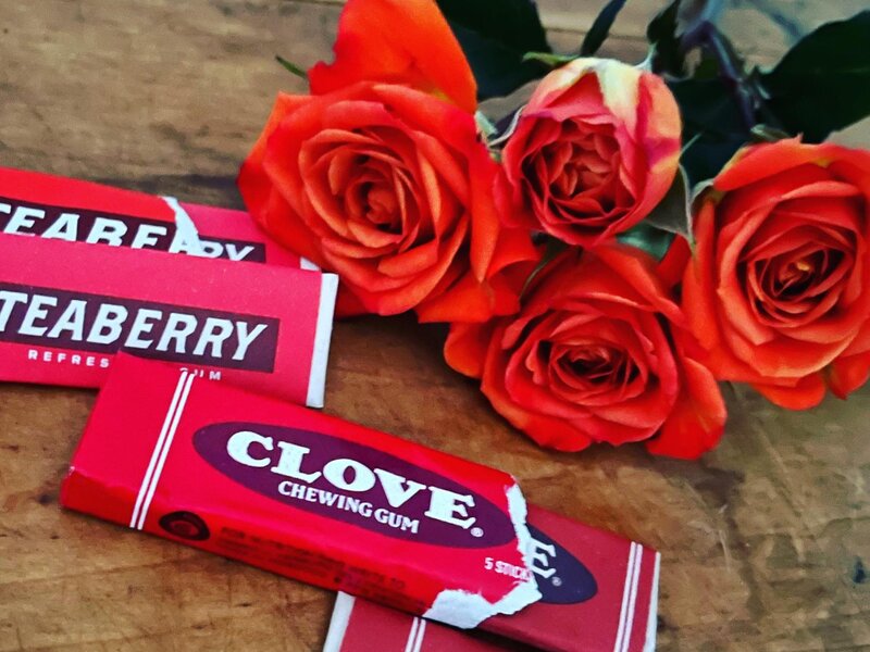 orange roses next to a pack of gum