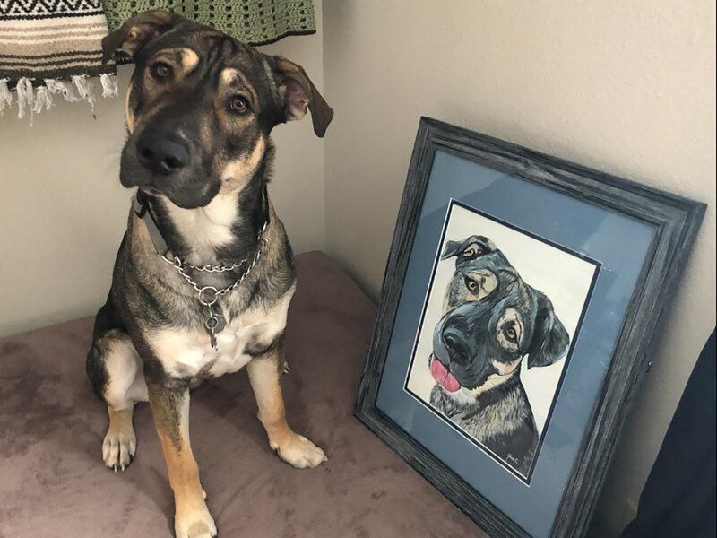 Dog poses with his painted portrait on canvas.