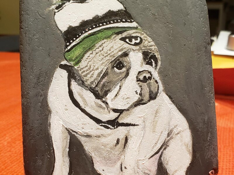 Painting of Donnie Wahlberg's white and grey bulldog that passed, wearing a winter hat.