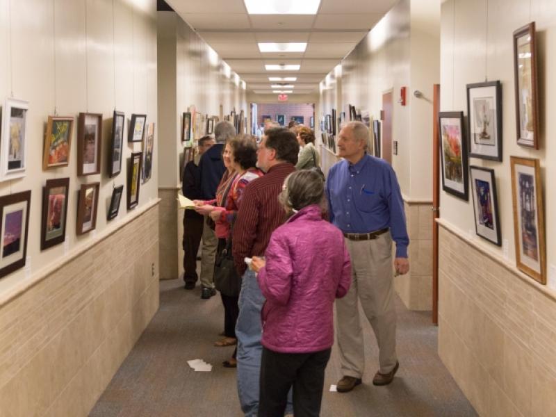 9th Annual Exhibit Attendees browsing the artwork filled hallways of the Regional Emergency Training Center at Camden County College