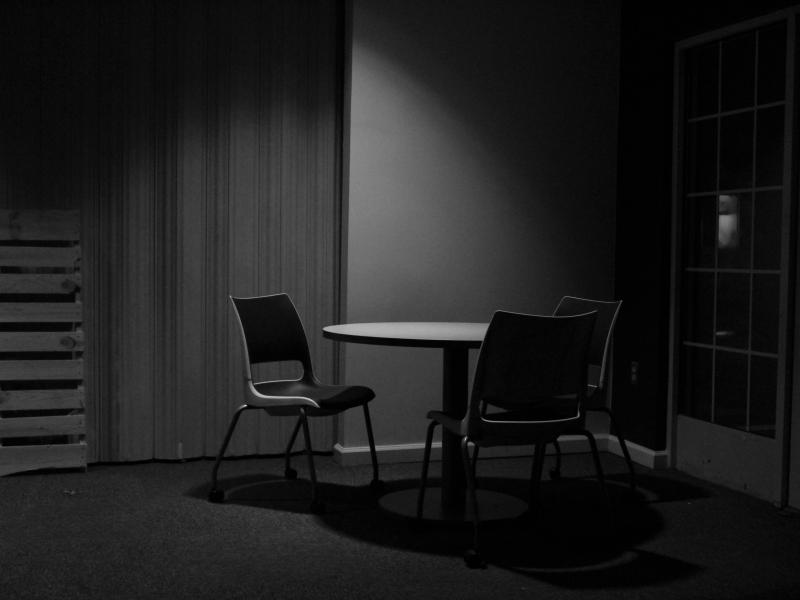 black and white photograph of an empty table and chairs