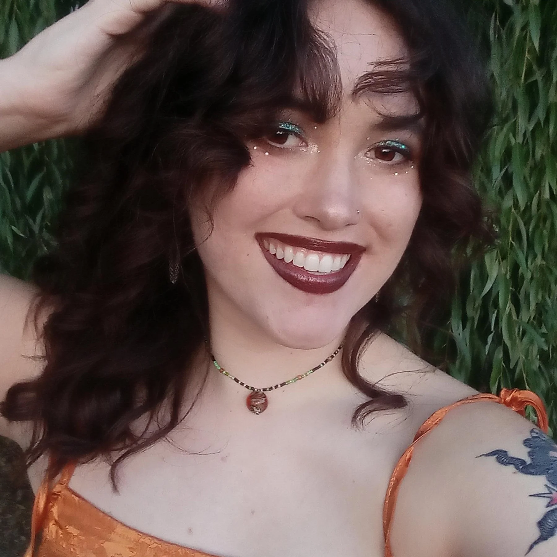Brunette woman with brown eyes and dark lipstick smiling