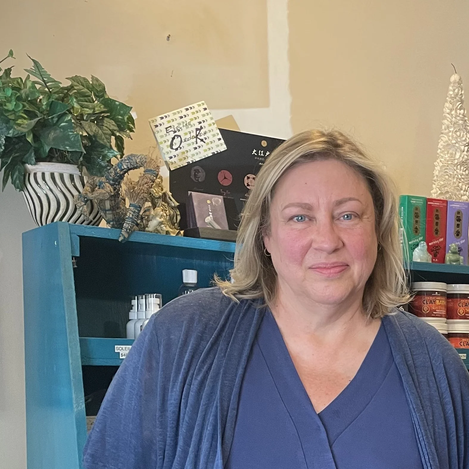 Portrait of artist, Laura Hill, standing in front of bookcase