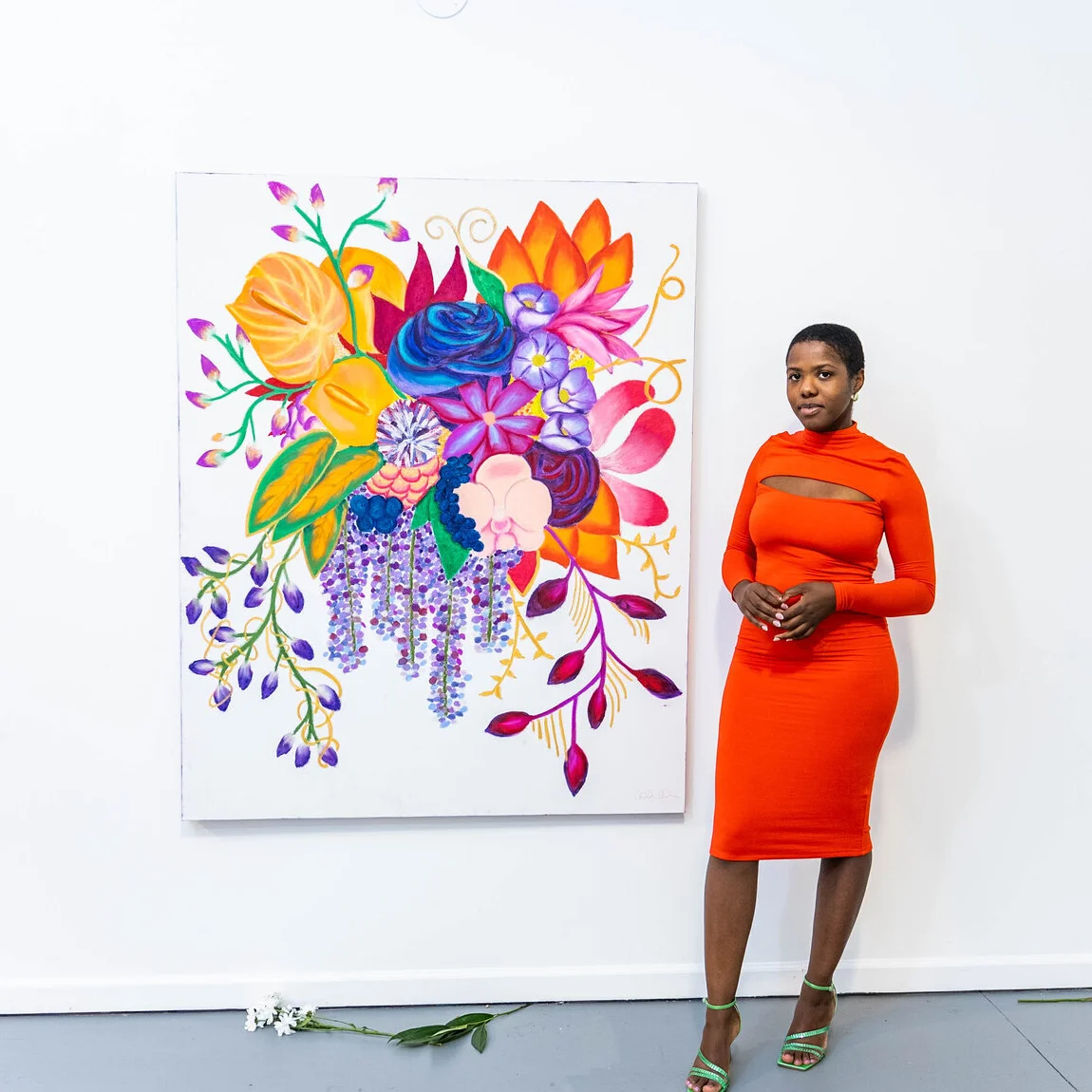 Tahirah Coleman standing next to large vibrant floral masterpiece