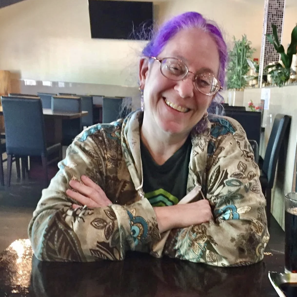 Purple hair lady, smiling with glasses 