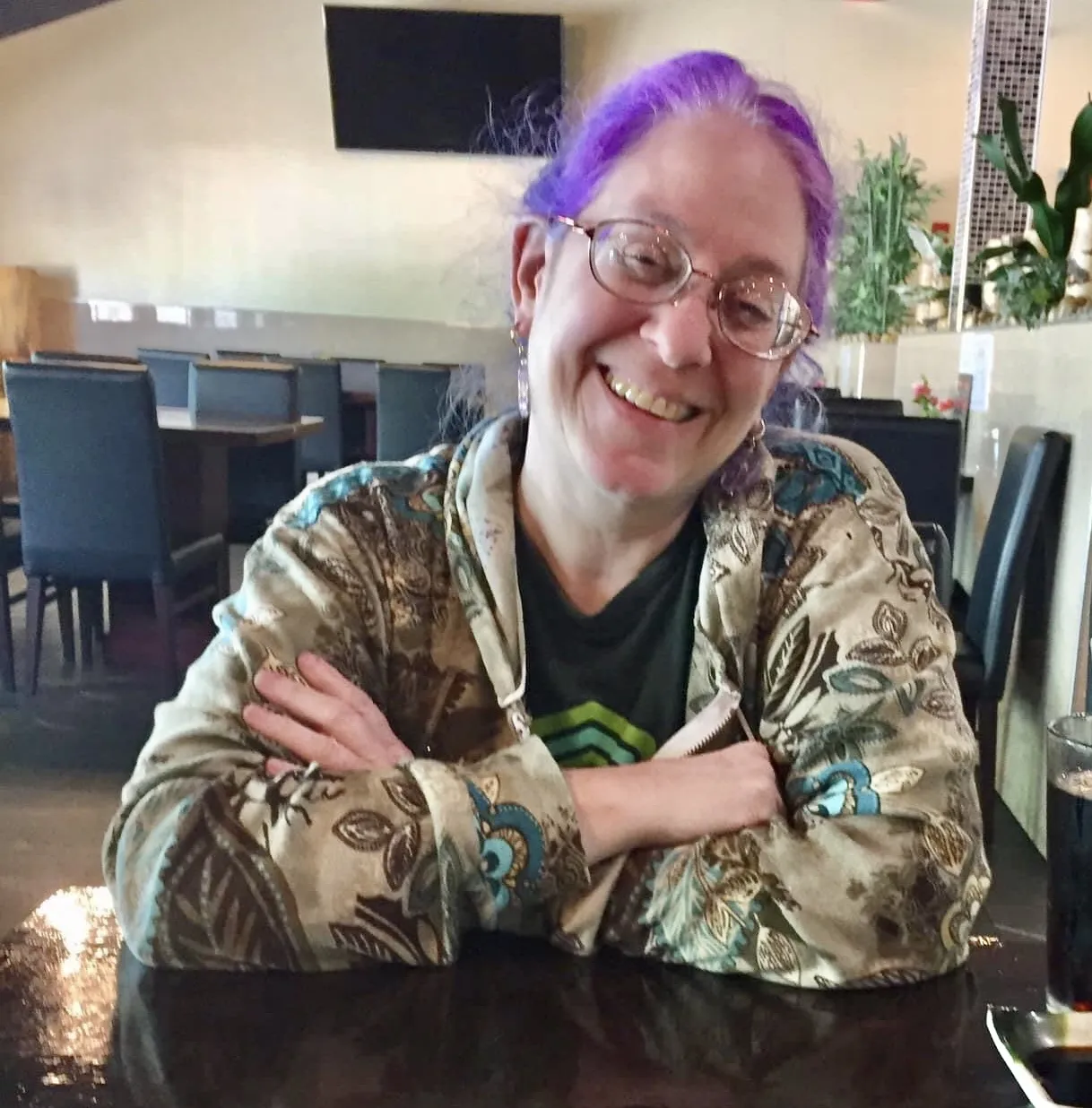 Purple hair lady, smiling with glasses 