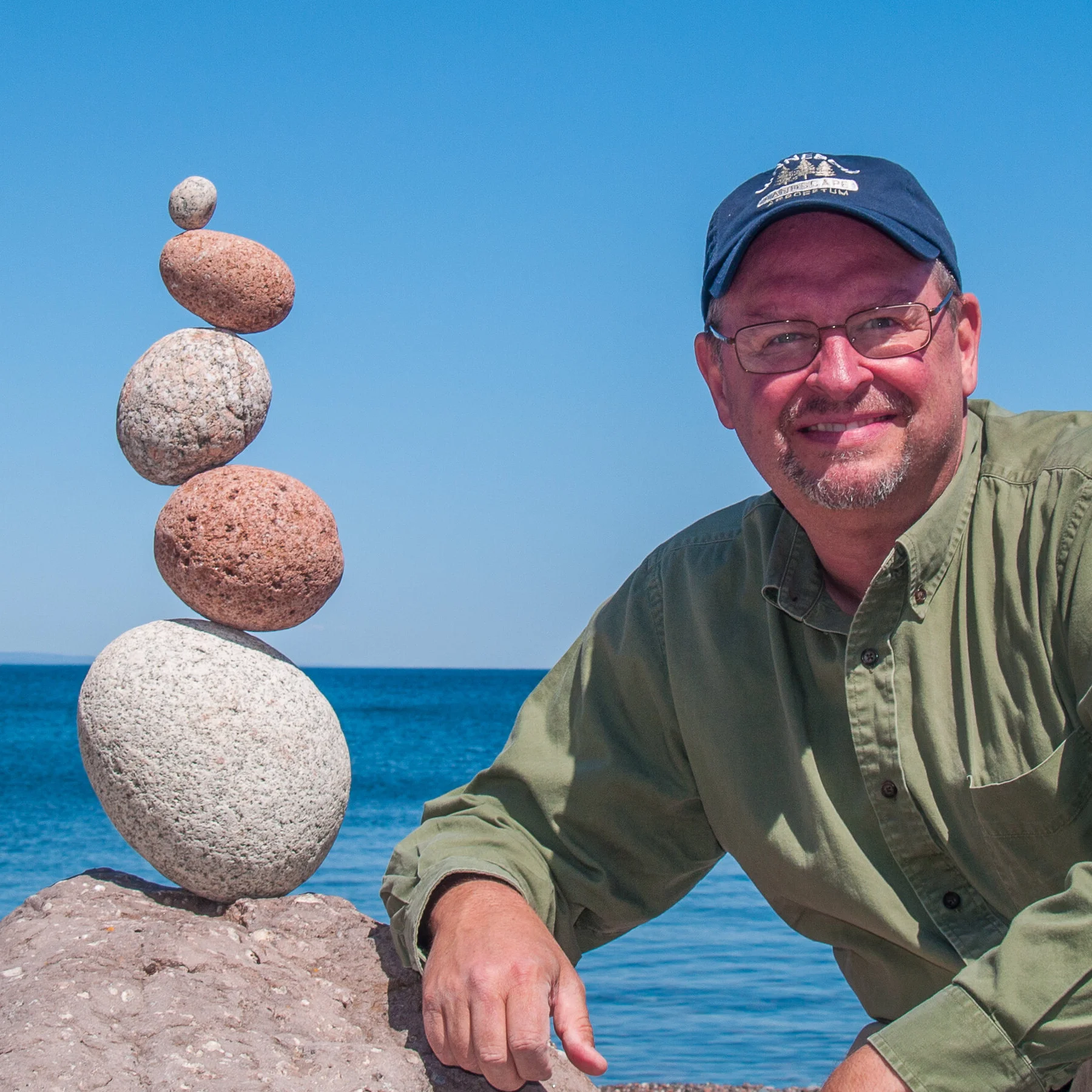 Photo of Peter Juhl with a stone balance sculptire
