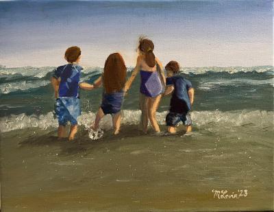 Four children on beach holding hands as the shallow ocean waves splash at their feet.