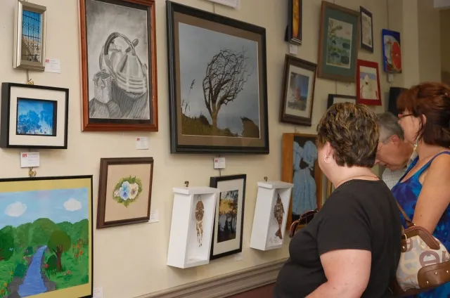 6th Annual Exhibit Attendees admiring one of the walls filled with artwork