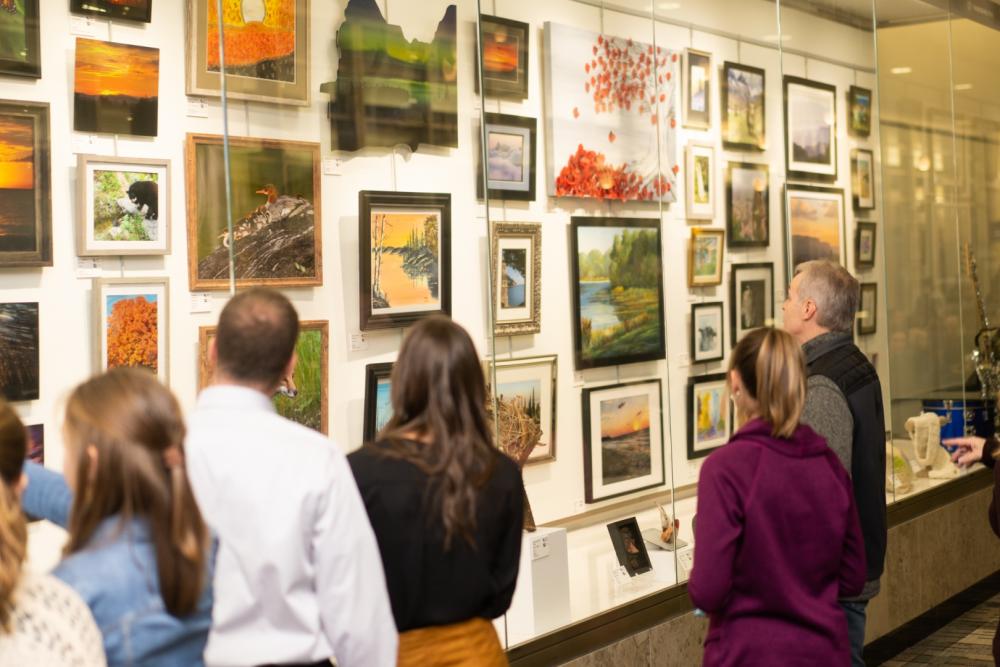 9th Annual Exhibit Attendees taking in one of  beautiful cases of artwork on display at the MSP International Airport