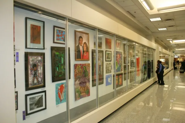 1st Exhibit Employees and travelers pausing to take in the artwork on display in the Gallery T Display Cases