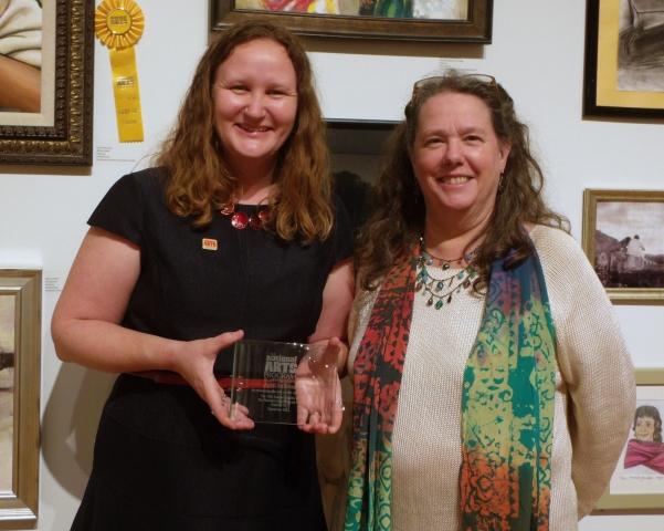 10th Annual Exhibit Venue Coordinator April Sullivan (L) proudly showing off her 10th Anniversary Award from the NAP with VSA Texas Executive Director Celia Hughes